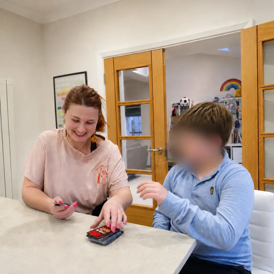 Antonia supporting children in a warm setting.